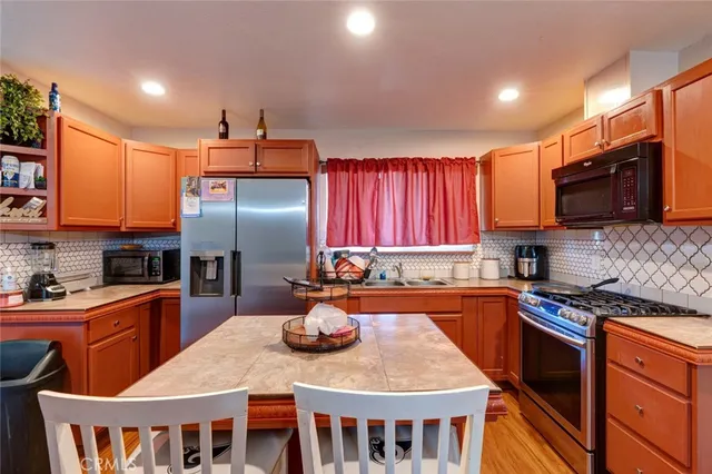 a kitchen with stainless steel appliances granite countertop a sink stove and refrigerator