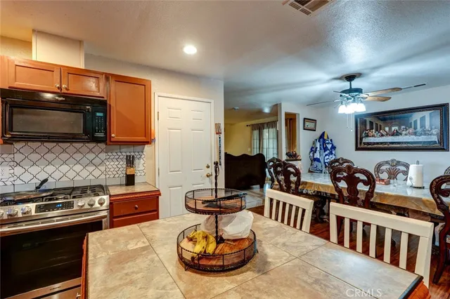 a kitchen with a stove a microwave and dining table
