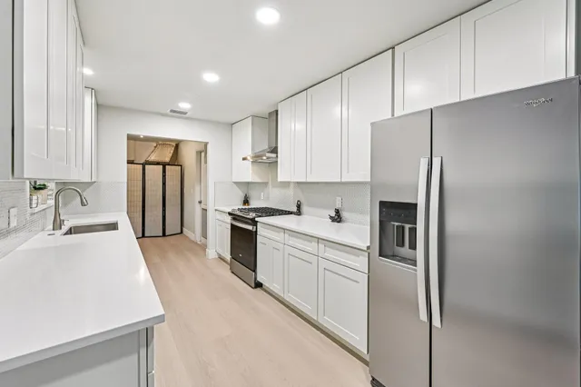 a kitchen with stainless steel appliances a refrigerator sink and cabinets