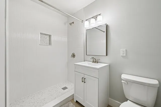 a bathroom with a sink a toilet and shower