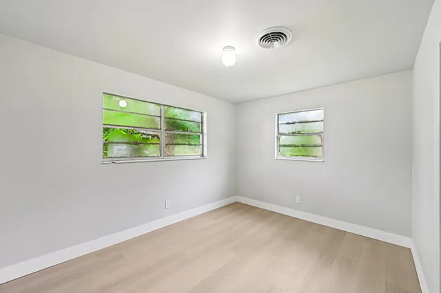 an empty room with windows and closet