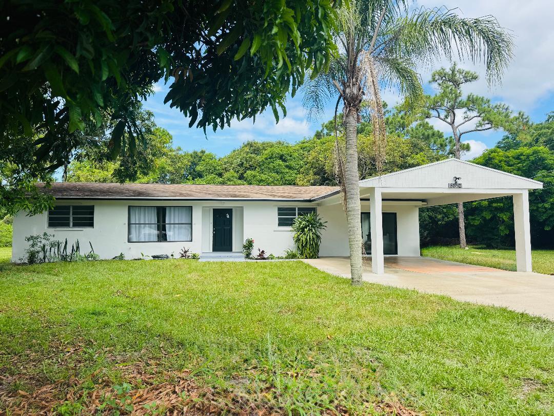 5852 Southeast Wesley Avenue Stuart, FL 34997 - Photo 5 of 27 a front view of a house with a garden