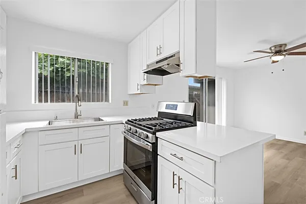 a kitchen with cabinets appliances a sink and a window