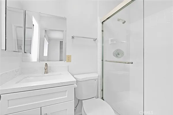 a bathroom with a sink toilet vanity and shower