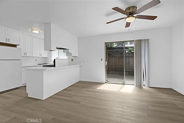 a view of kitchen with granite countertop cabinets and refrigerator