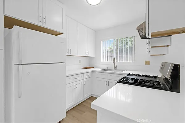 a kitchen with stainless steel appliances a refrigerator sink and white cabinets