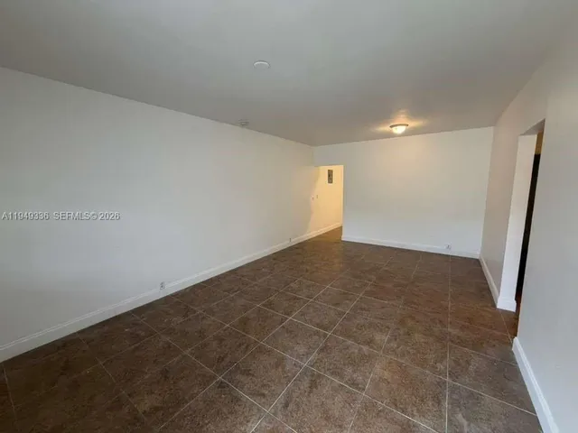 an empty room with an entrance to other room