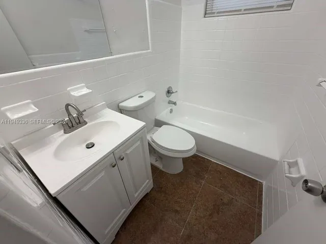 a bathroom with a sink mirror toilet and bathtub