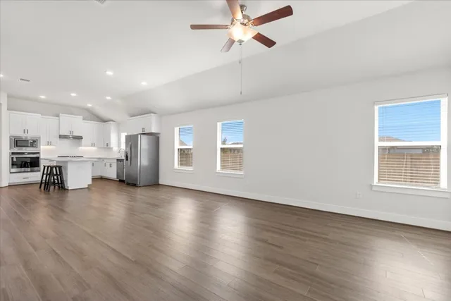 a view of empty room with wooden floor and windows