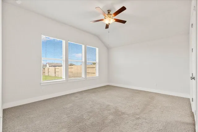 an empty room with a window and a ceiling fan