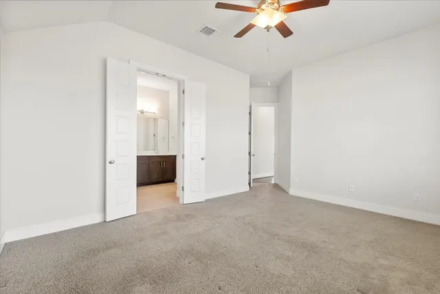 an empty room with chandelier fan