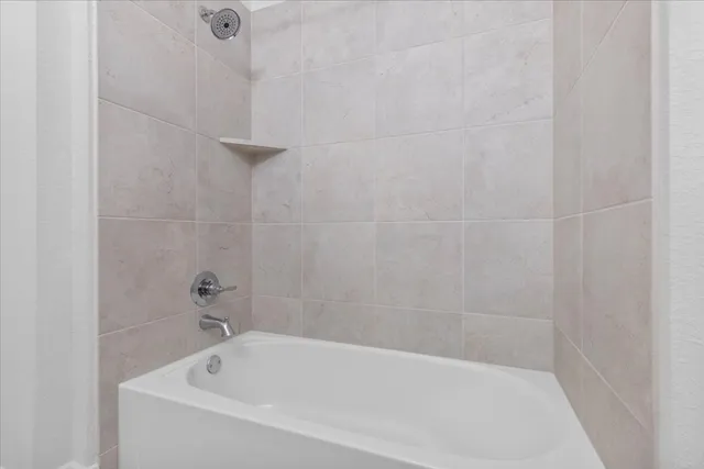 a white bath tub sitting next to a white sink and vanity