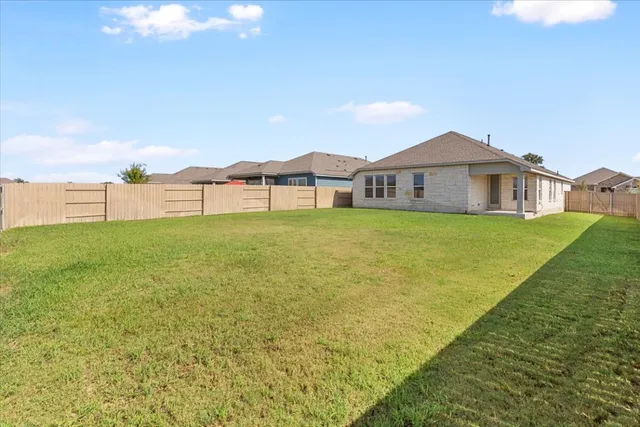 a view of a house with a big yard and large trees