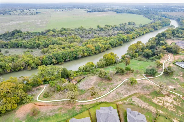 an aerial view of residential houses with outdoor space and lake view