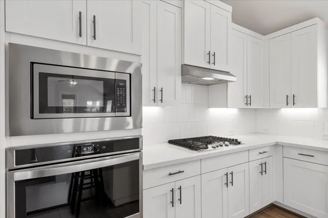 a kitchen with stainless steel appliances granite countertop a stove and a microwave