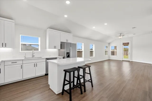 a large kitchen with stainless steel appliances lots of counter space and wooden floor