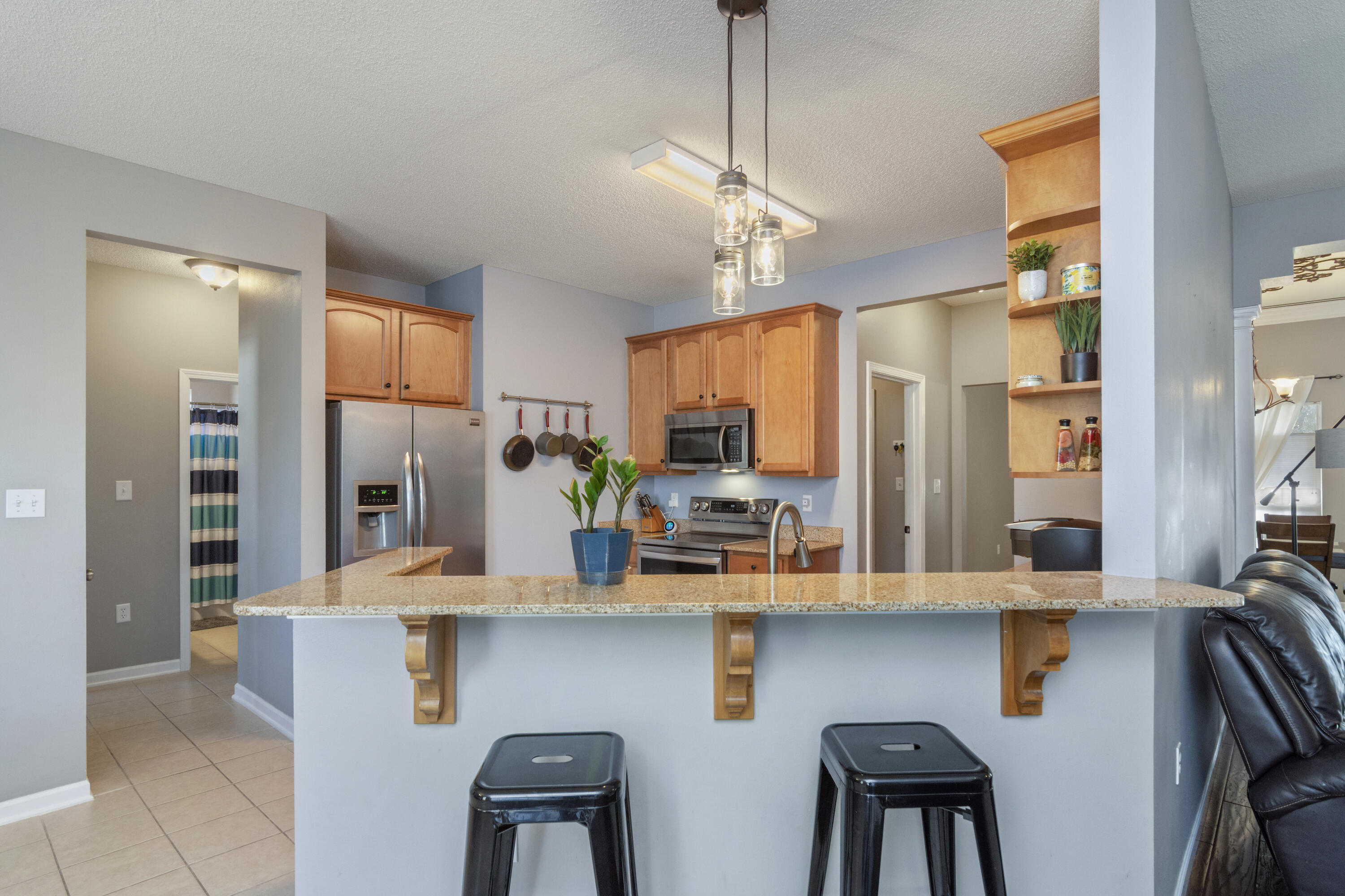 4631 Hermosa Road Crestview, FL 32539 - Photo 20 of 42 a kitchen with stainless steel appliances kitchen island granite countertop a refrigerator and microwave