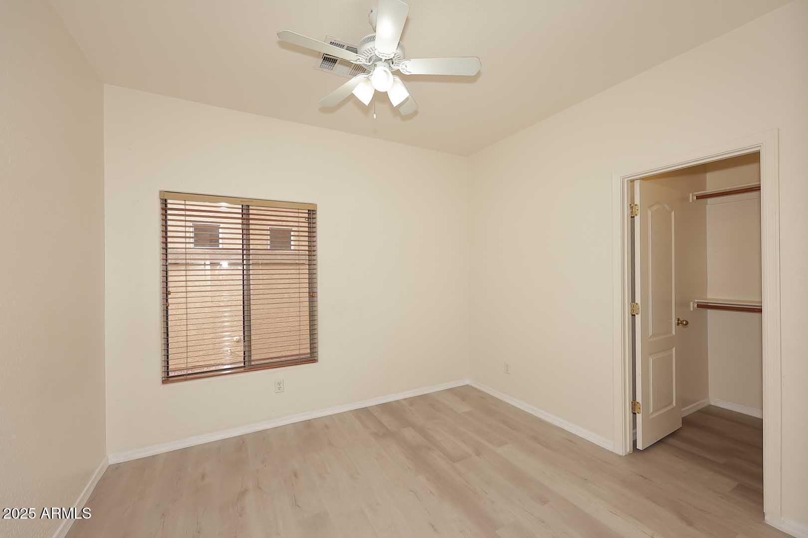 2710 East Chester Drive Chandler, AZ 85286 - Photo 16 of 28 an empty room with wooden floor chandelier fan and windows