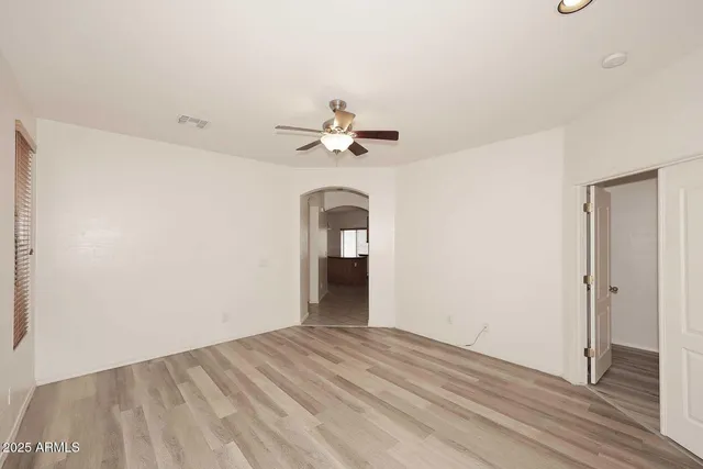 a view of a room with a ceiling fan and hardwood floor