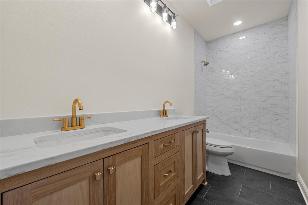 5200 Bogey Lane Waco, TX 76708 - Photo 21 of 37 a bathroom with a granite countertop sink a toilet and a bathtub