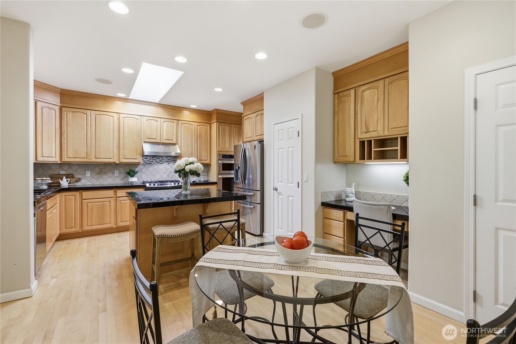 4354 Northwest Westgate Road Silverdale, WA 98383 - Photo 9 of 40 a kitchen with granite countertop kitchen island stainless steel appliances a stove a sink a refrigerator cabinets and a dining table