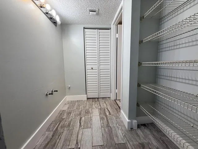a view of a room with wooden floor and white walls