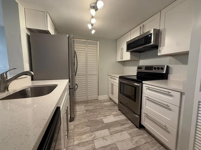 a kitchen with stainless steel appliances granite countertop a sink and a stove