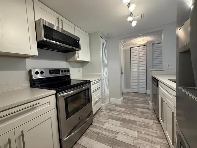 a kitchen with stainless steel appliances granite countertop a stove and a microwave
