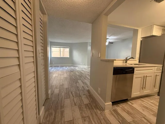 a kitchen with a refrigerator and wooden floor