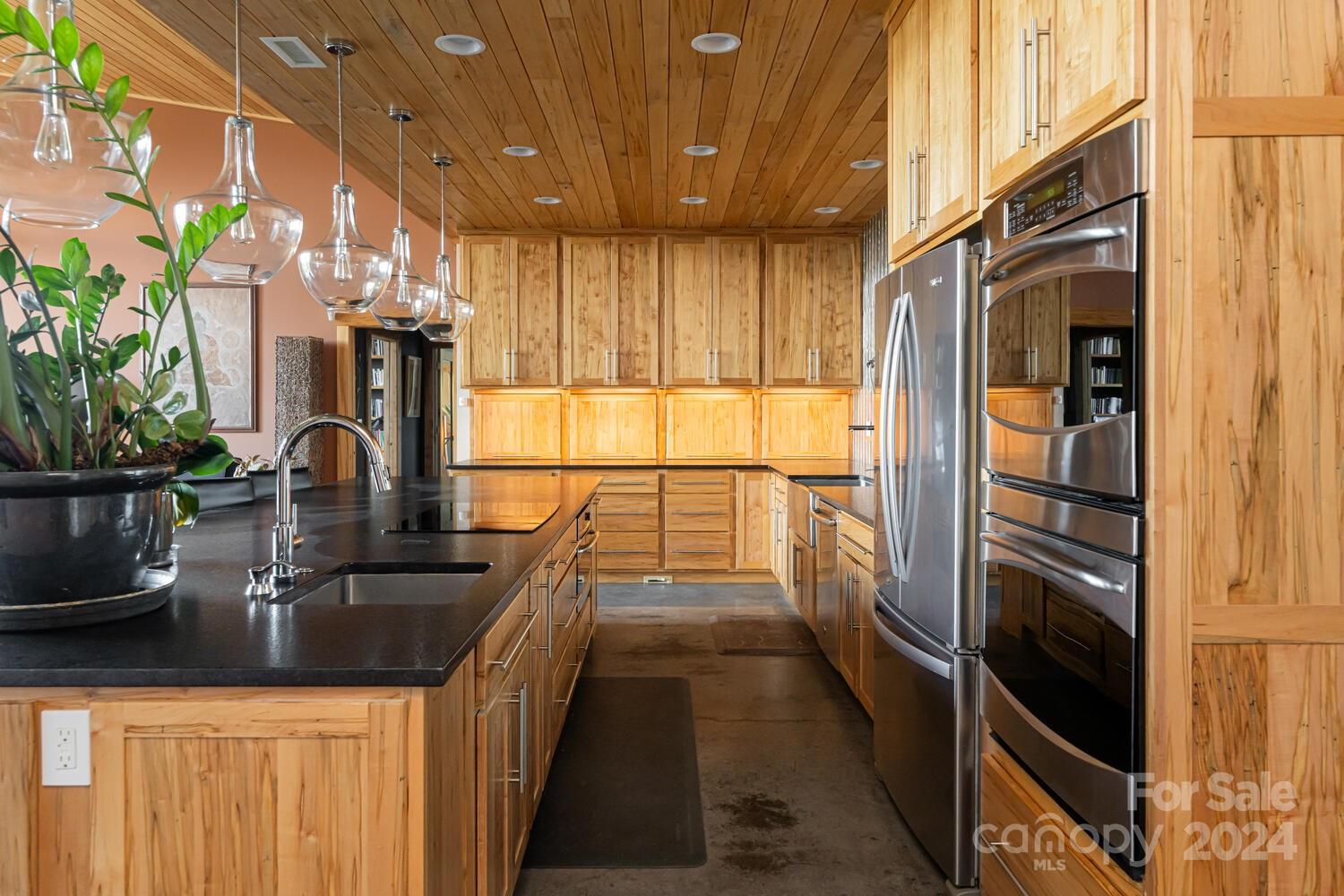 265 Alexander Road Alexander, NC 28701 - Photo 13 of 48 a kitchen with kitchen island a sink appliances and cabinets