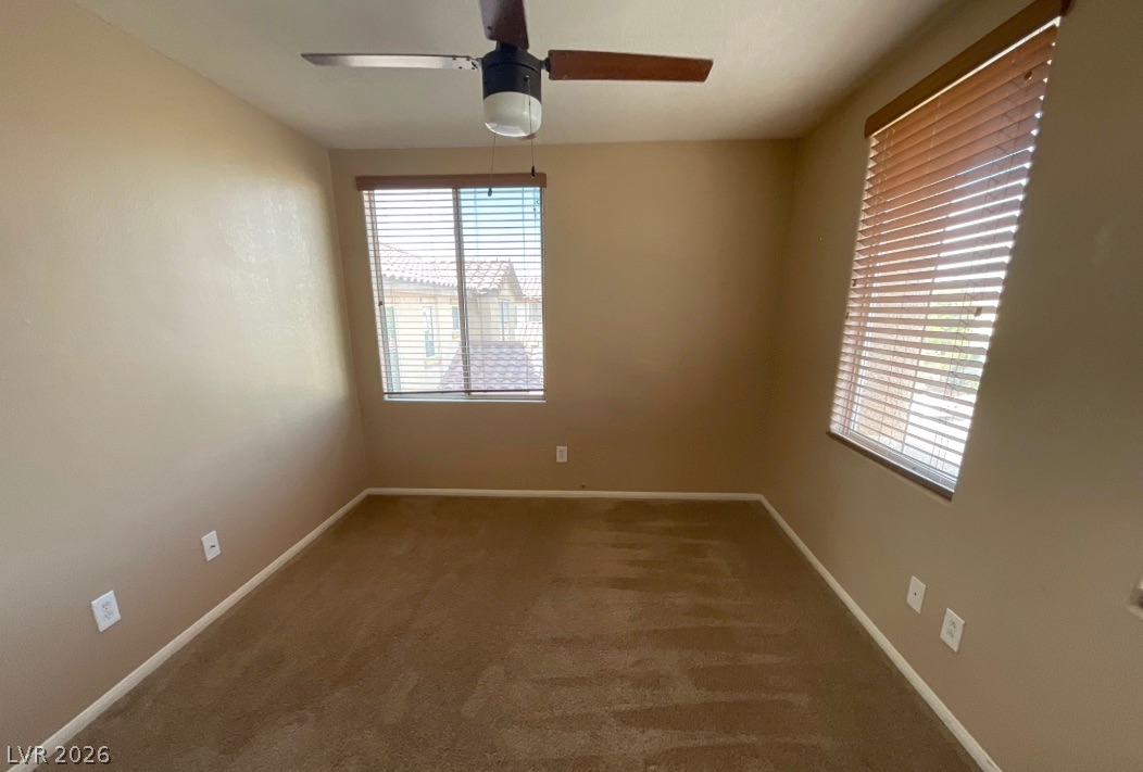 10841 Paradise Road Henderson, NV 89052 - Photo 22 of 35 A well-lit room offering plush carpeting and a convenient ceiling fan for comfort.