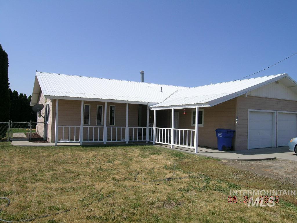 View of front of house featuring covered porch and a metal roof