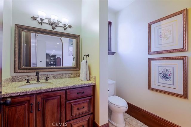 a bathroom with a granite countertop sink a toilet and a mirror