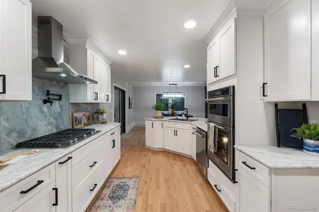 a large kitchen with stainless steel appliances lots of counter space sink and stove