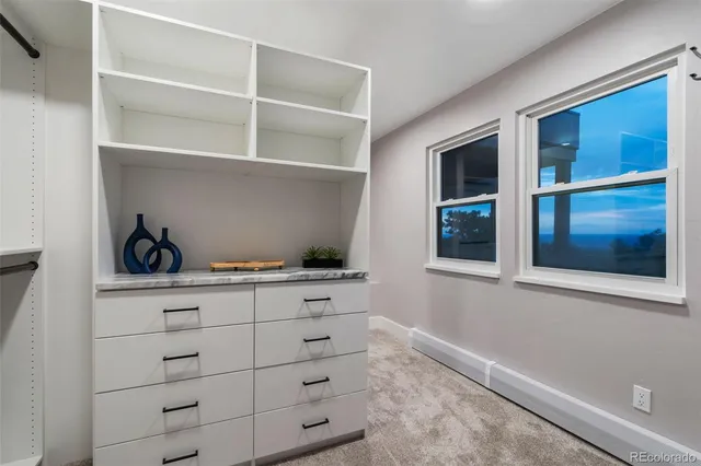 a kitchen with white cabinets and a window