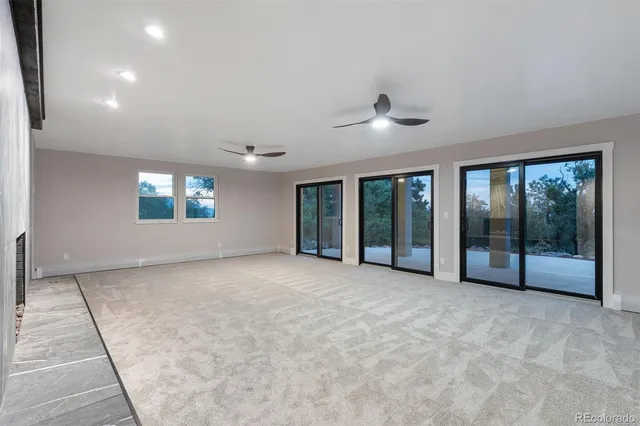 a view of an empty room with a window and a fireplace