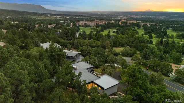an aerial view of residential house with outdoor space and trees all around