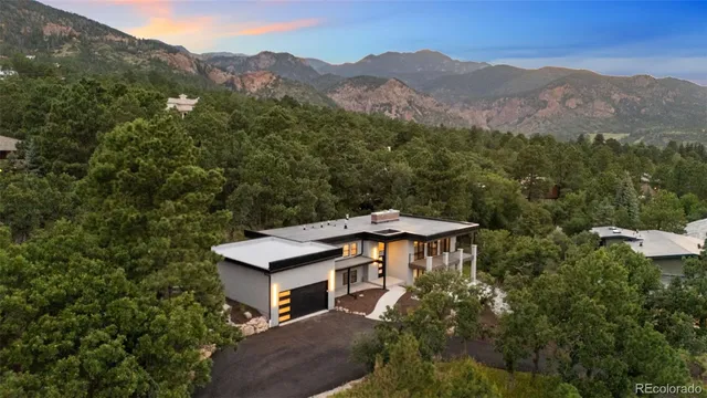 an aerial view of a house with a mountain in the background