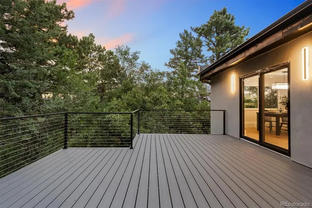 a balcony with wooden floor in front of house