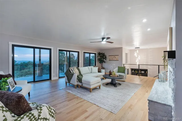 a living room with furniture large window and wooden floor