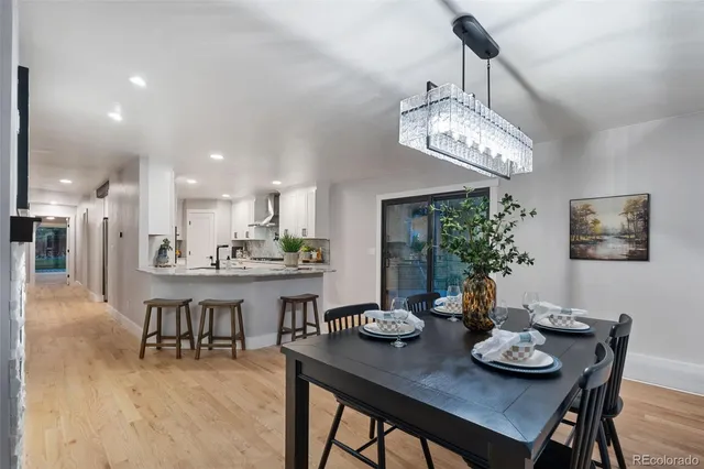 a view of a dining room with furniture a chandelier and wooden floor