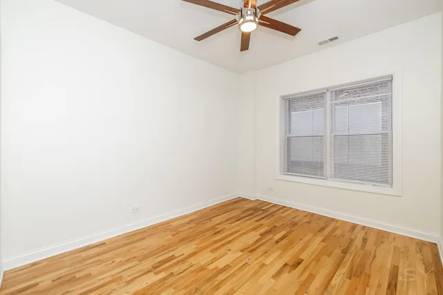 an empty room with a window and a fan
