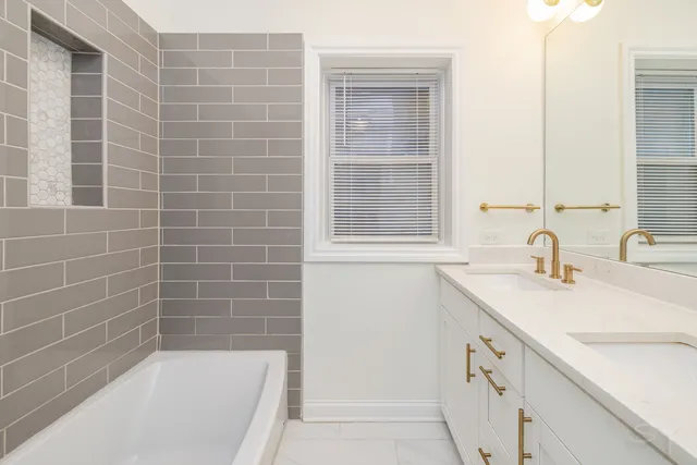a bathroom with a sink a vanity and a bathtub