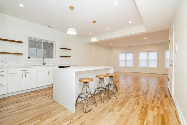 a view of a kitchen with wooden floor and outdoor space
