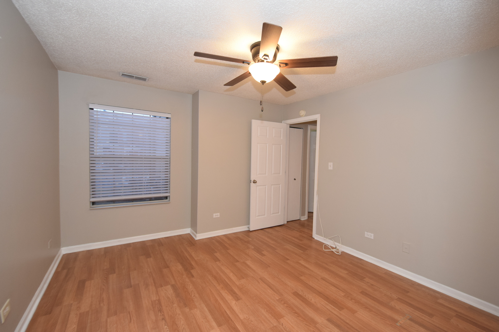 1959 North Hicks Road, Unit 103 Palatine, IL 60074 - Photo 13 of 22 a view of an empty room with wooden floor and a ceiling fan