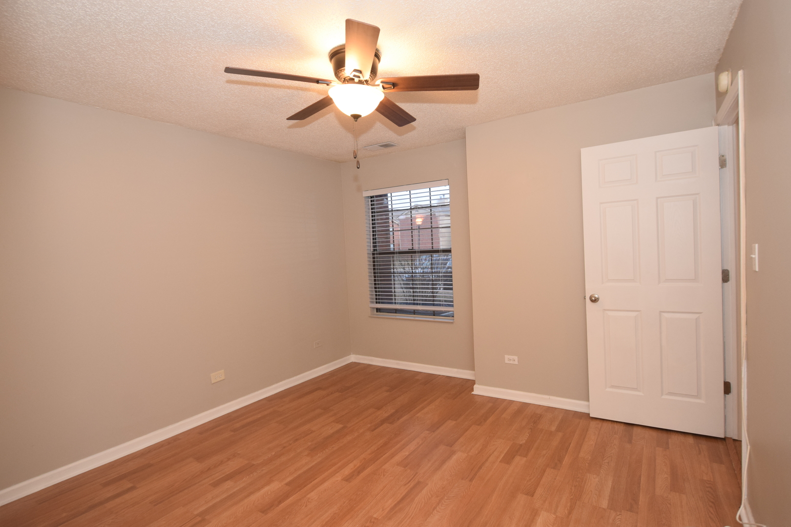1959 North Hicks Road, Unit 103 Palatine, IL 60074 - Photo 17 of 22 an empty room with wooden floor fan and windows