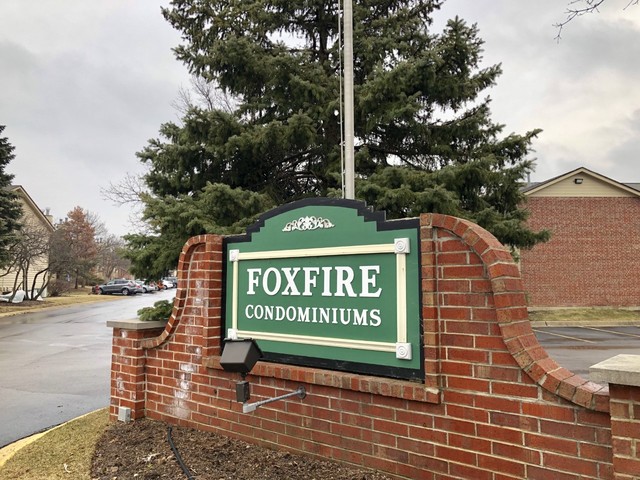1959 North Hicks Road, Unit 103 Palatine, IL 60074 - Photo 22 of 22 a sign on a brick wall with a tree