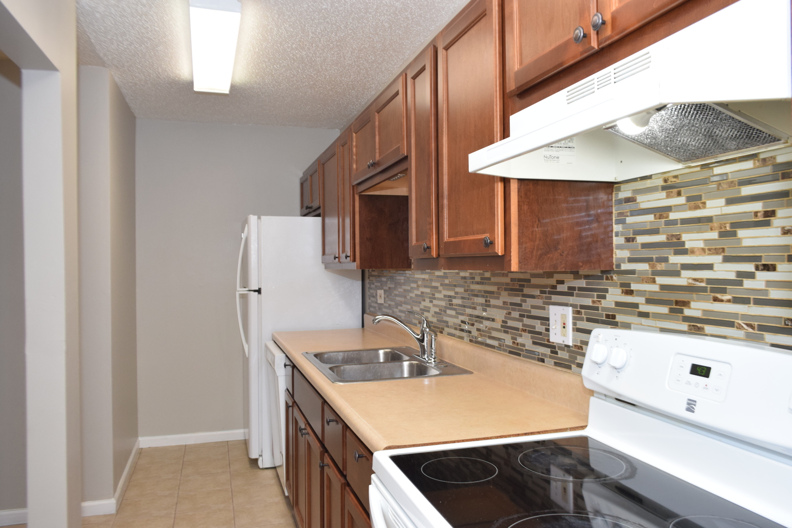 1959 North Hicks Road, Unit 103 Palatine, IL 60074 - Photo 7 of 22 a kitchen with a sink a stove and a refrigerator