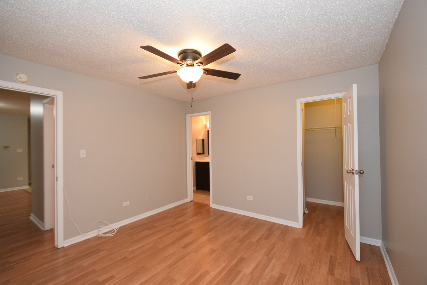1959 North Hicks Road, Unit 103 Palatine, IL 60074 - Photo 8 of 22 an empty room with wooden floor and a ceiling fan