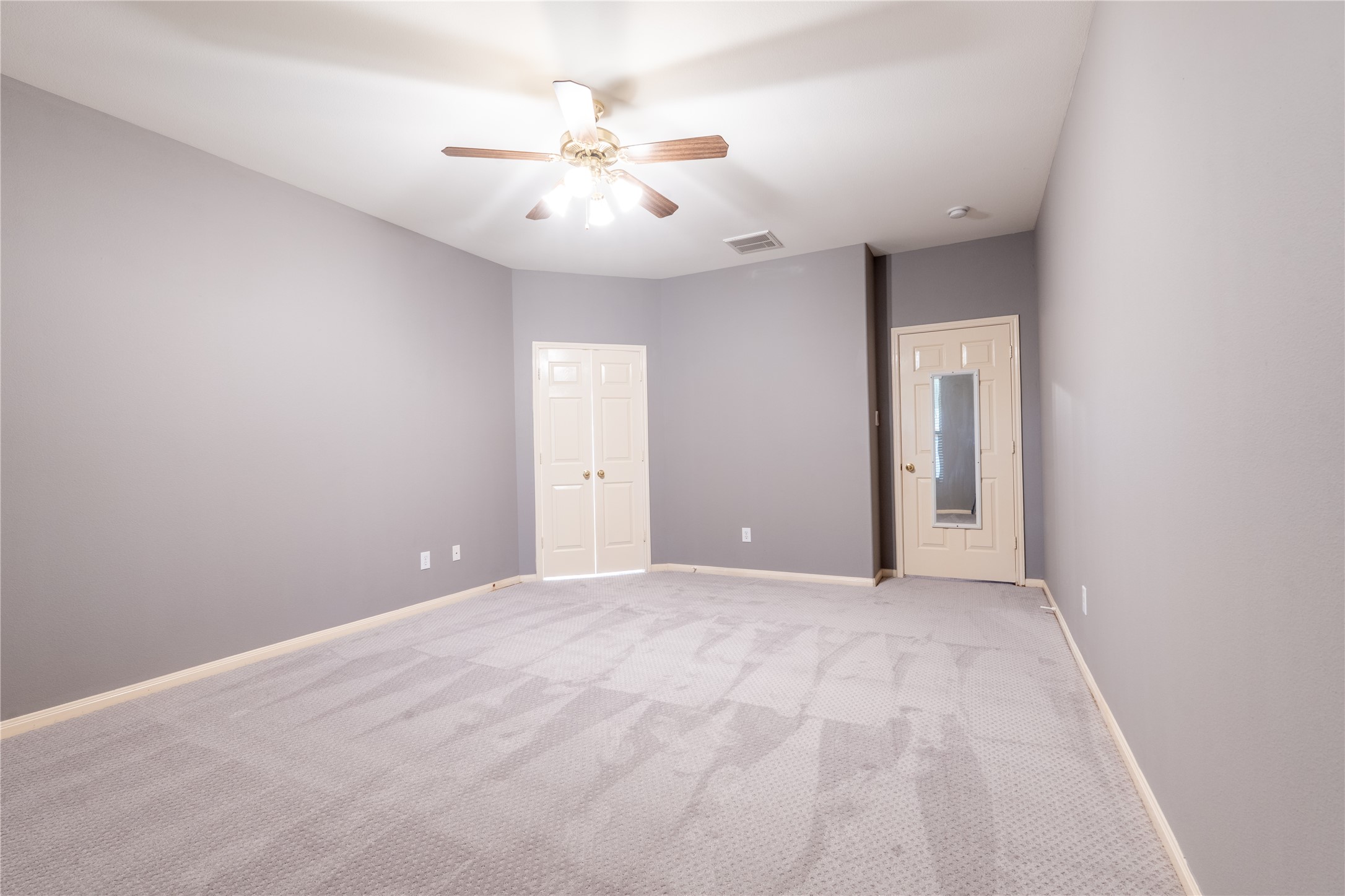 10619 Crownsedge Drive Spring, TX 77379 - Photo 13 of 38 This spacious primary room features soft gray walls, clean carpeting, and a ceiling fan with light. The double doors lead into the primary bath.